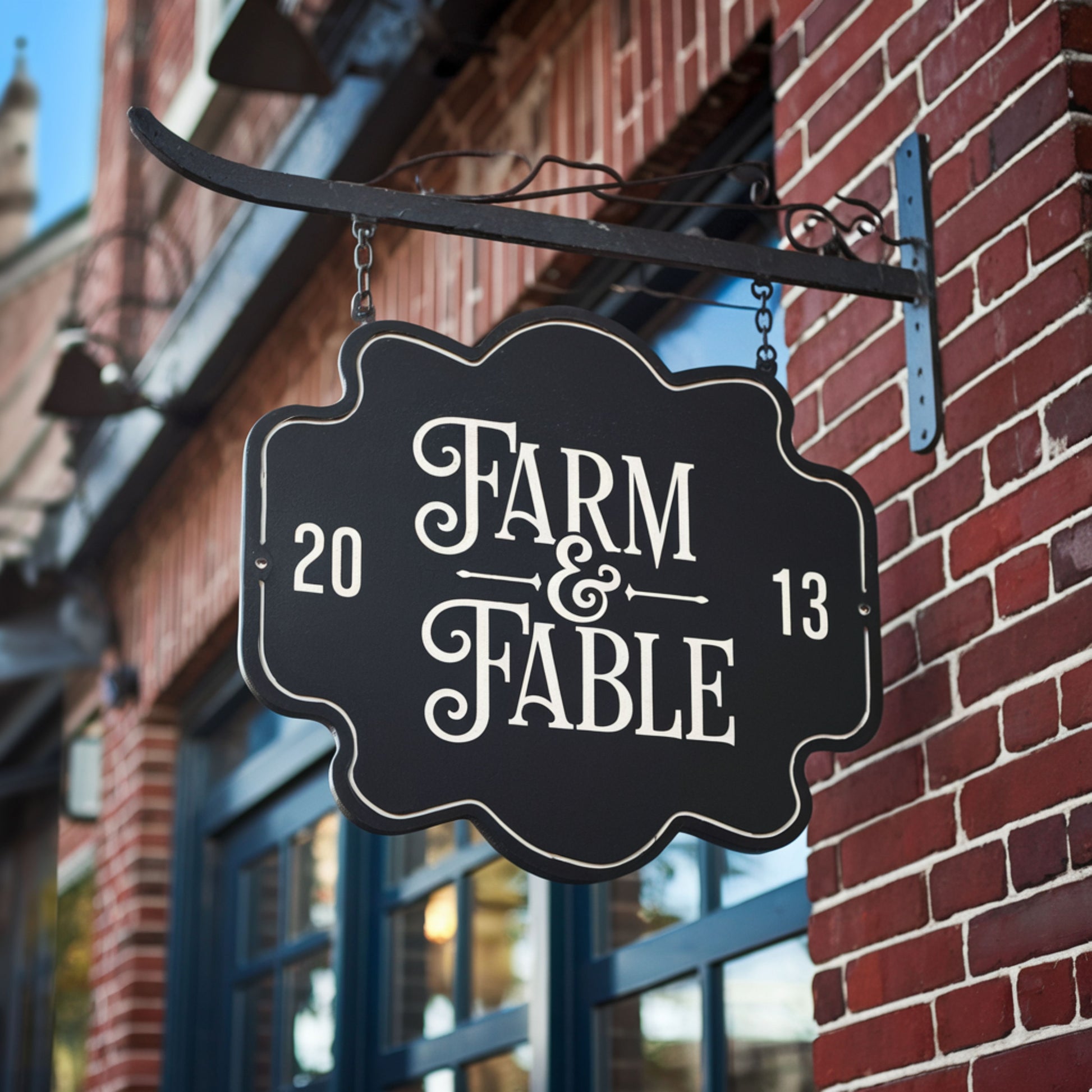 Sign for 'Farm & Fable' hanging on a brick building